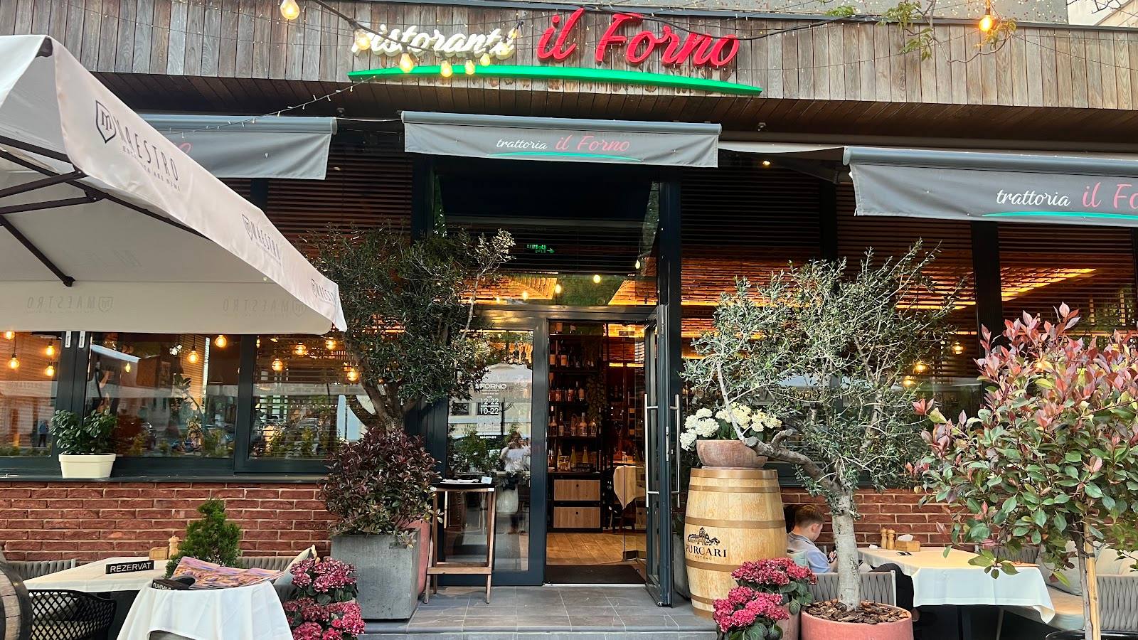 Wine bar storefront with brick facade, signage, outdoor seating and decorative plantings
