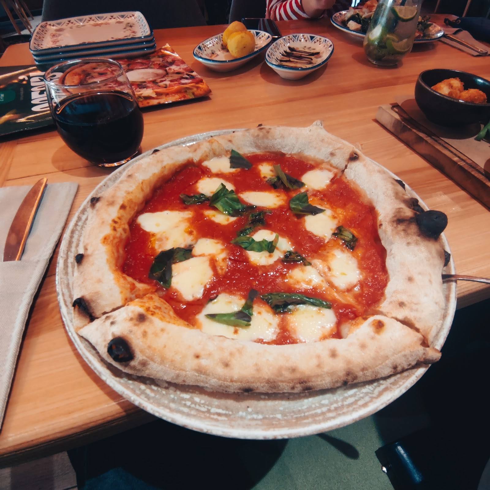 Margherita pizza with fresh mozzarella, basil, and tomato sauce on wooden table