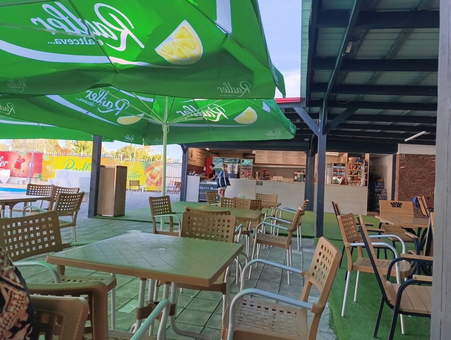 Casual dining area with green branding canopy and woven seating