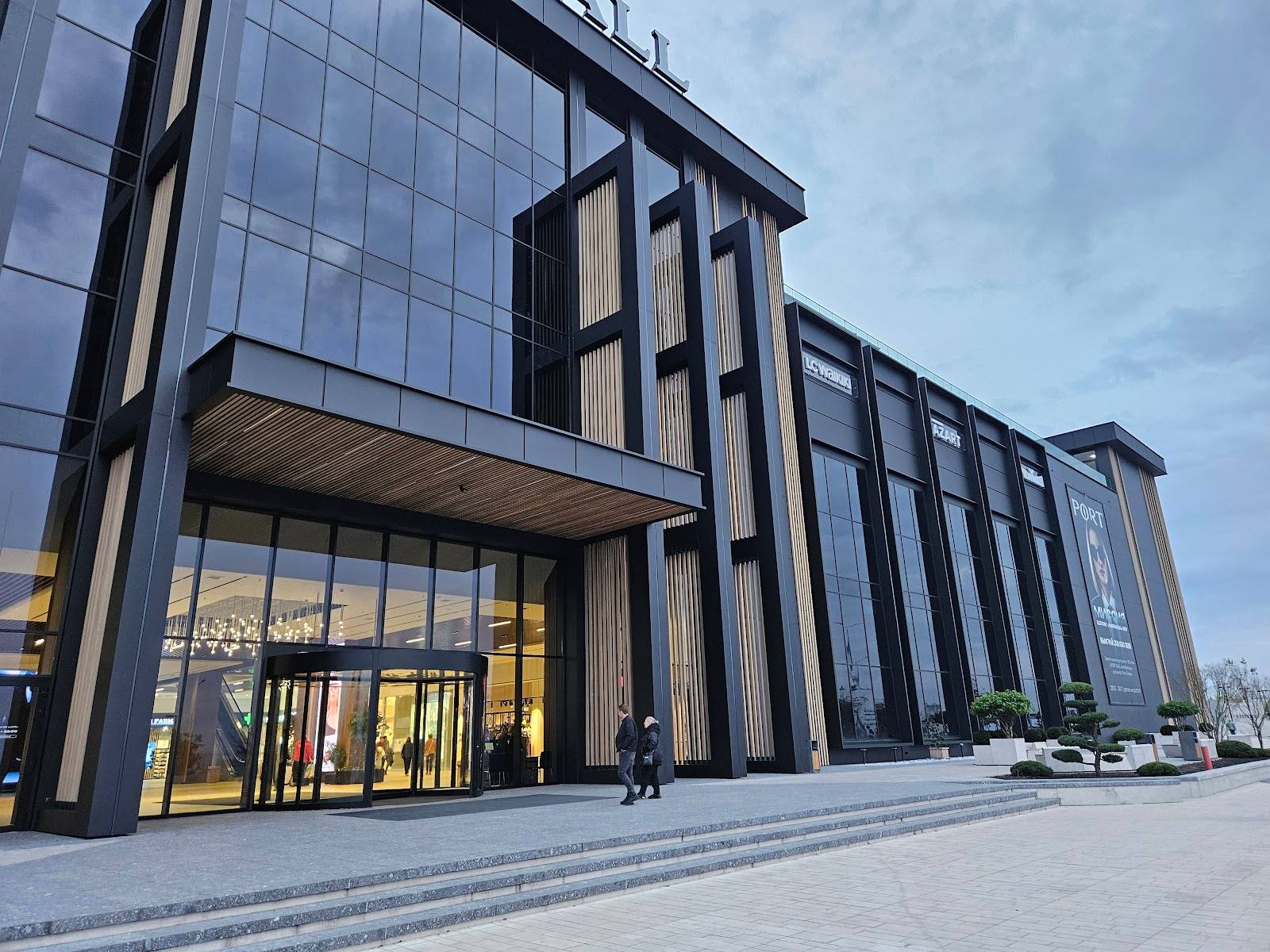 Modern multi-story venue building with glass and dark timber facade, ground-level entrance visible
