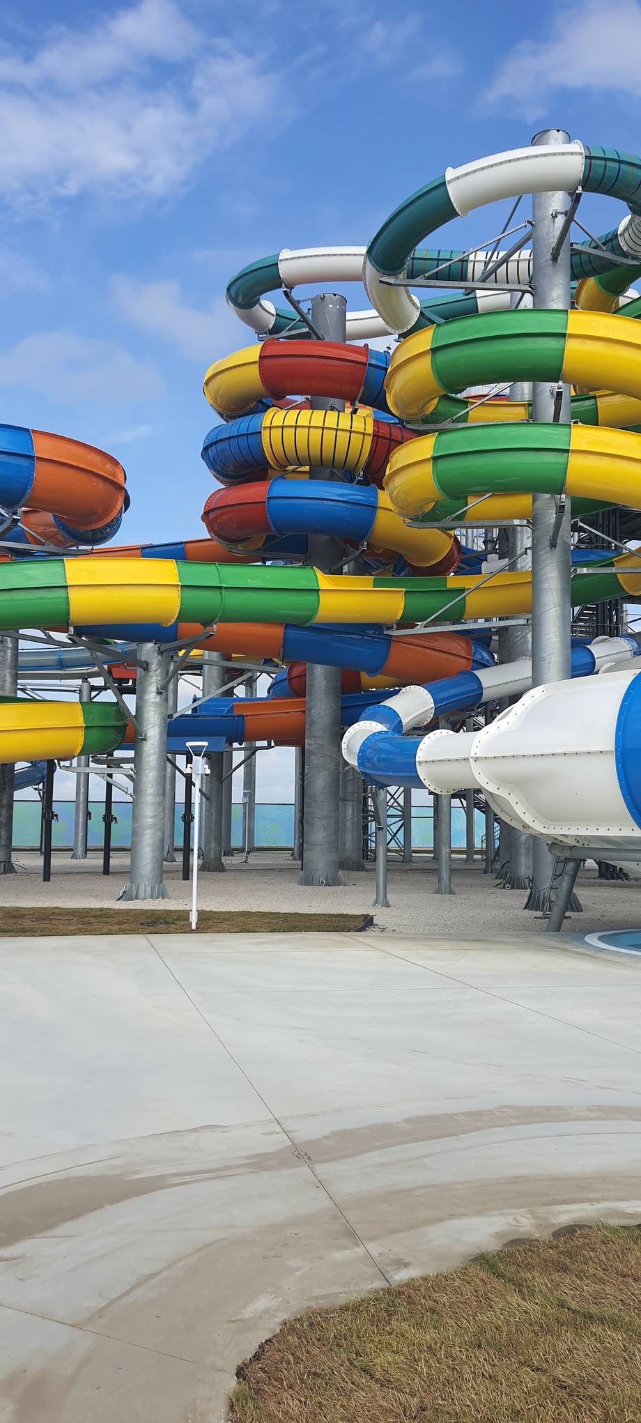 Colorful water slides tower against blue sky at outdoor aquatic park