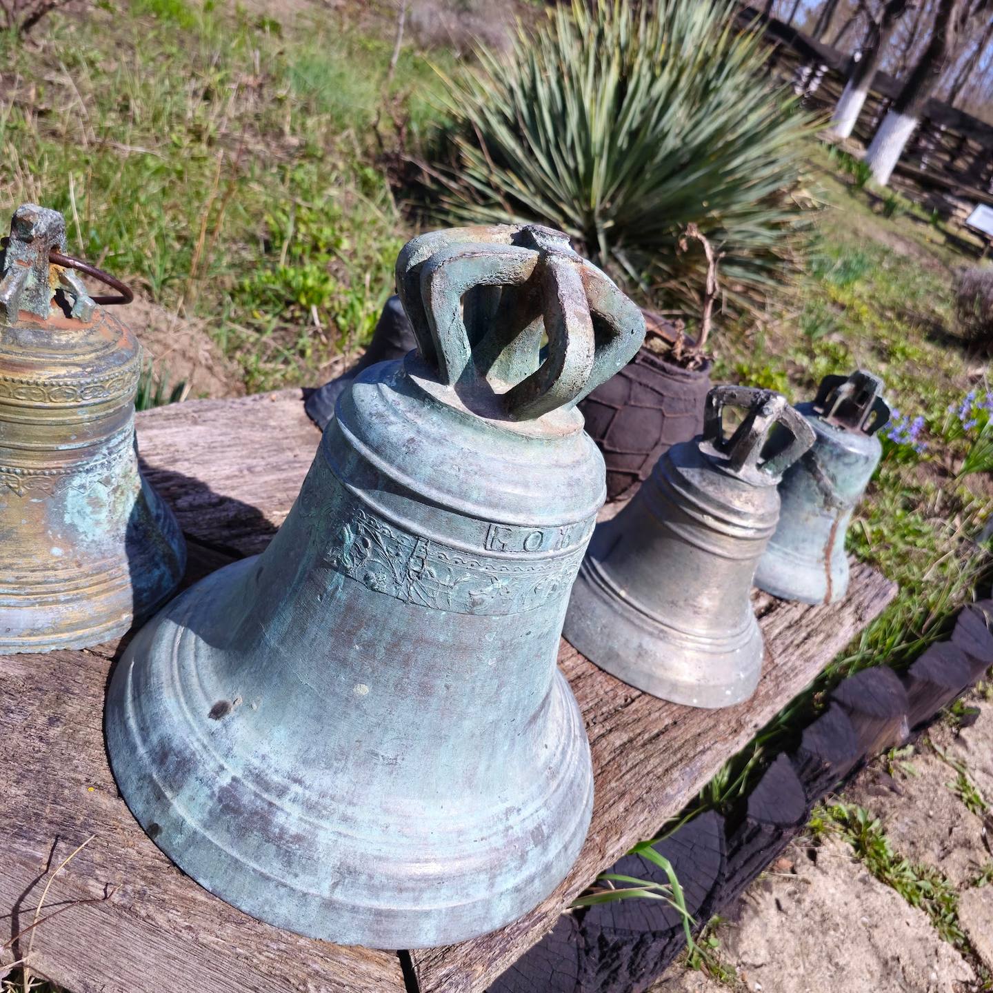 Historic church bells displayed outdoors with weathered patina