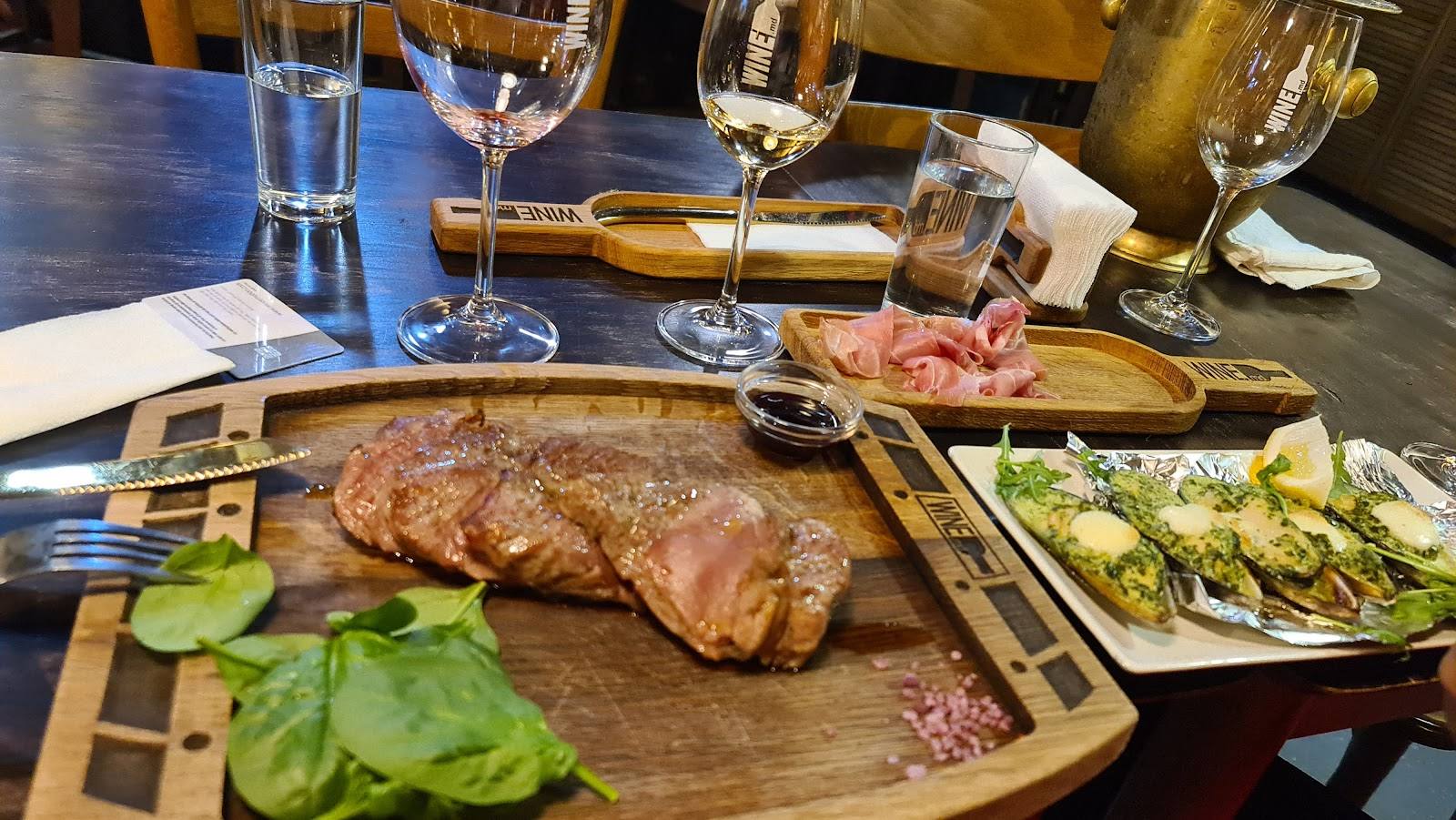 Charcuterie and grilled meat spread with wine service at table