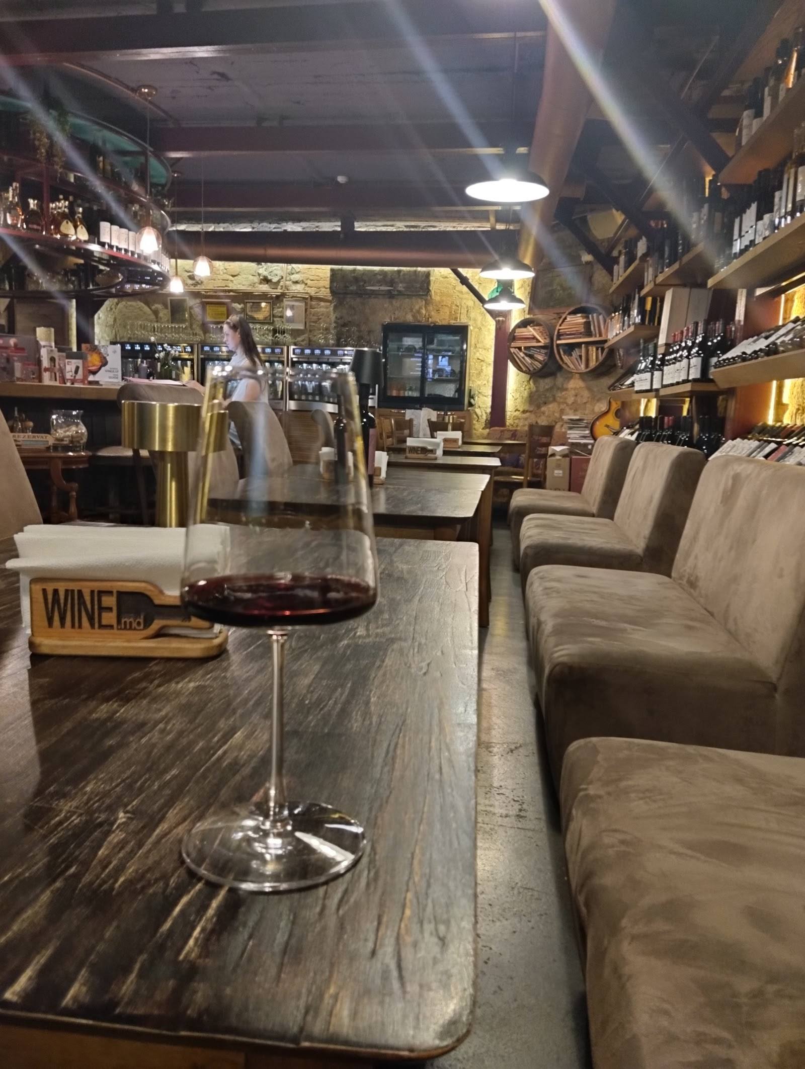 Wine bar interior with seating, bar counter, and wine display shelving