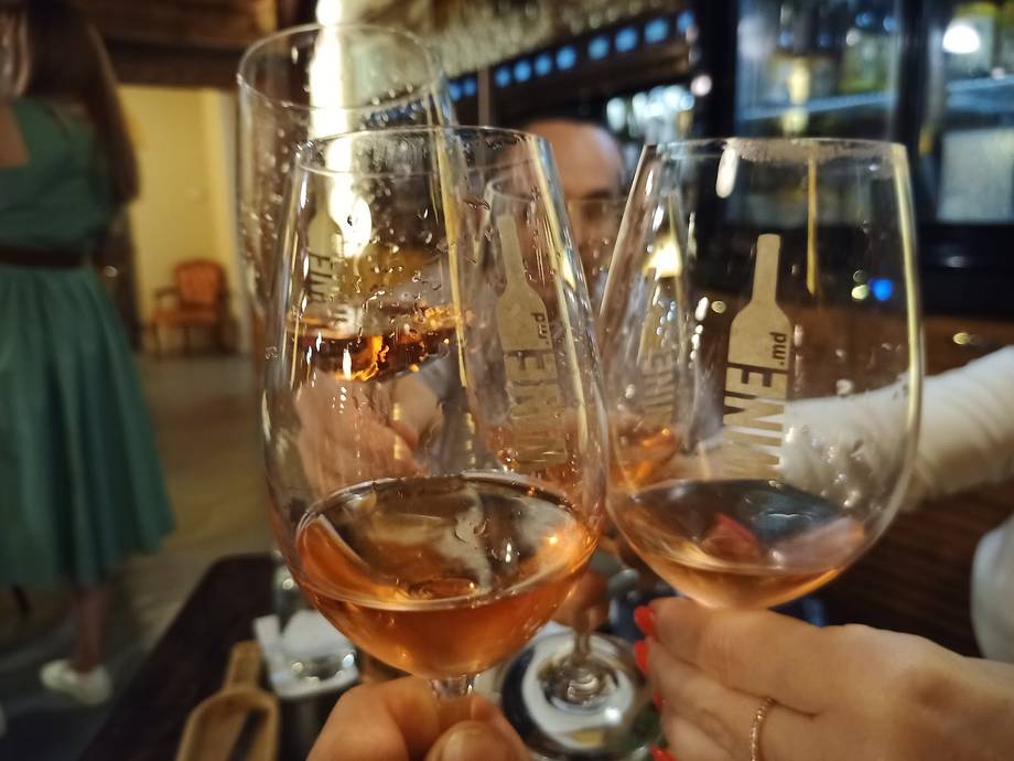 Two glasses of rosé wine toasting at a bar or restaurant venue