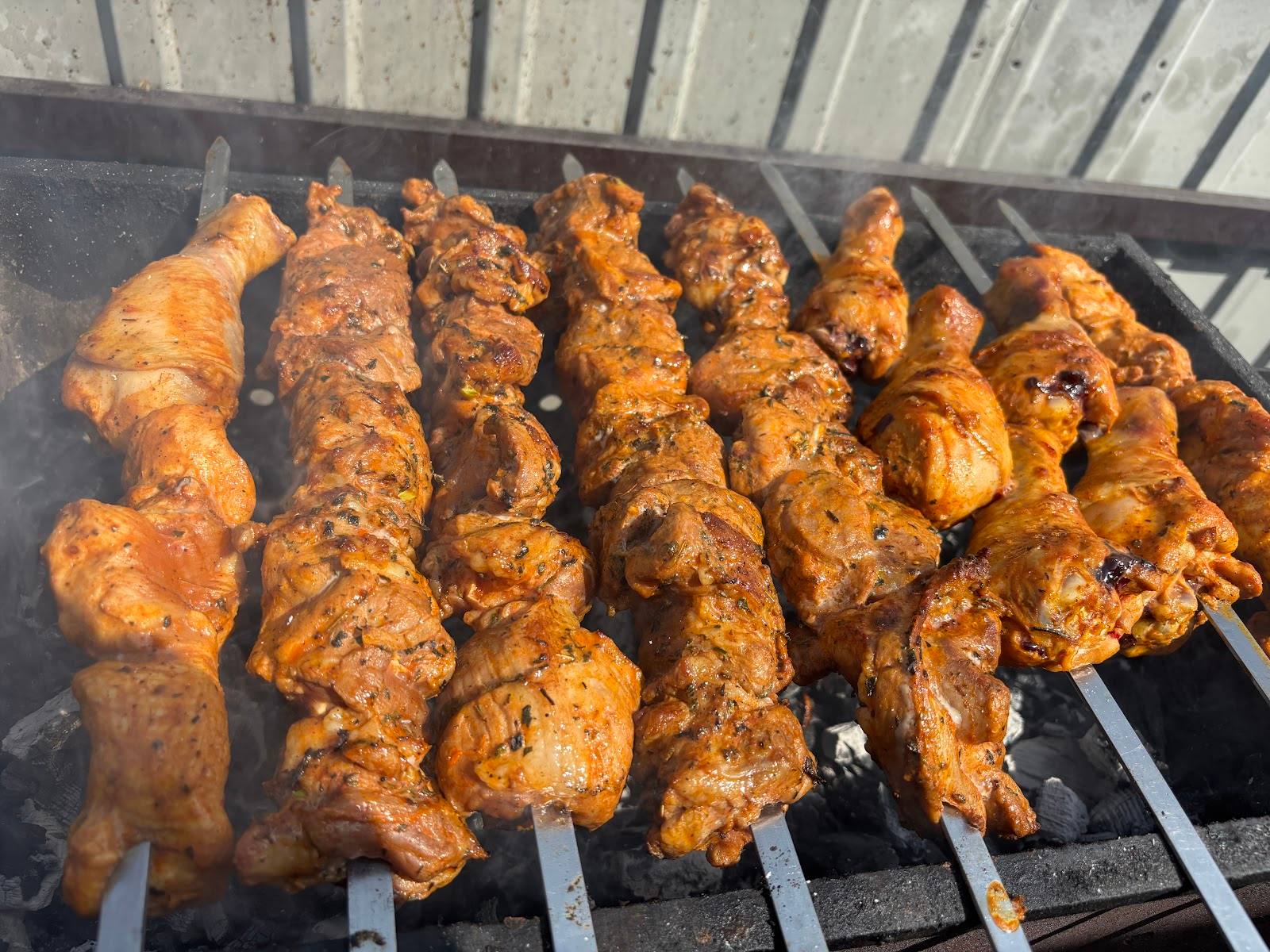 Grilled meat skewers on open flame barbecue