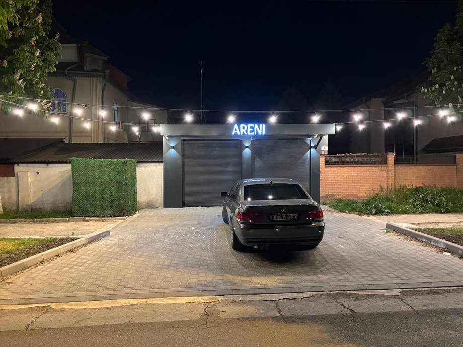 ARENI nightclub storefront with illuminated signage and parking lot at night