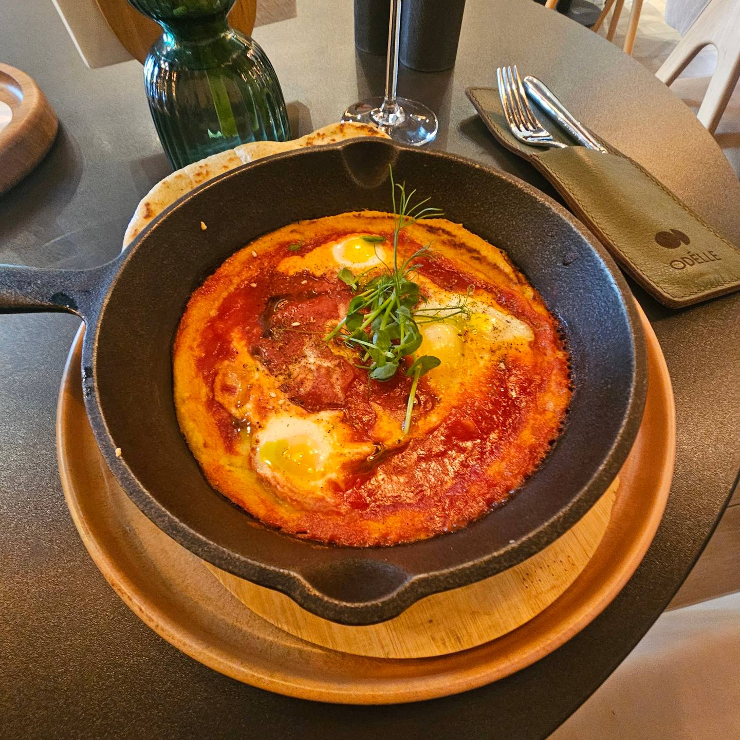 Baked egg dish with tomato and herbs in cast iron skillet