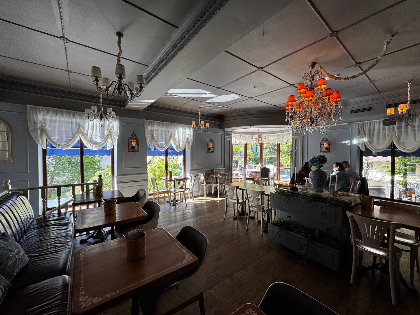 Elegant modern event space with crystal chandeliers, round dining tables, and floor-to-ceiling windows