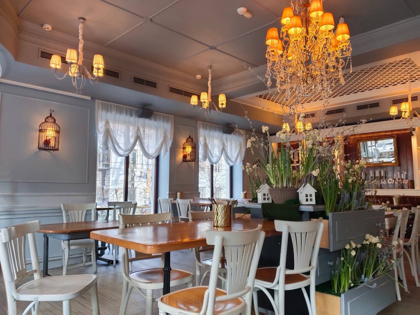 Elegant dining room with crystal chandeliers, natural lighting, and refined table settings