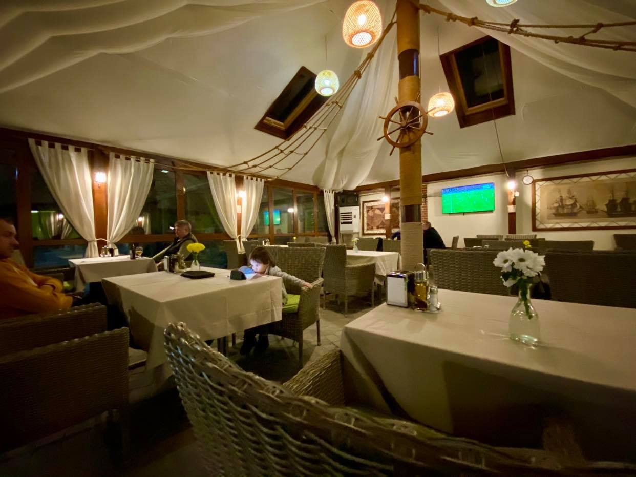 Elegant restaurant interior with draped ceiling, ambient lighting, and table seating