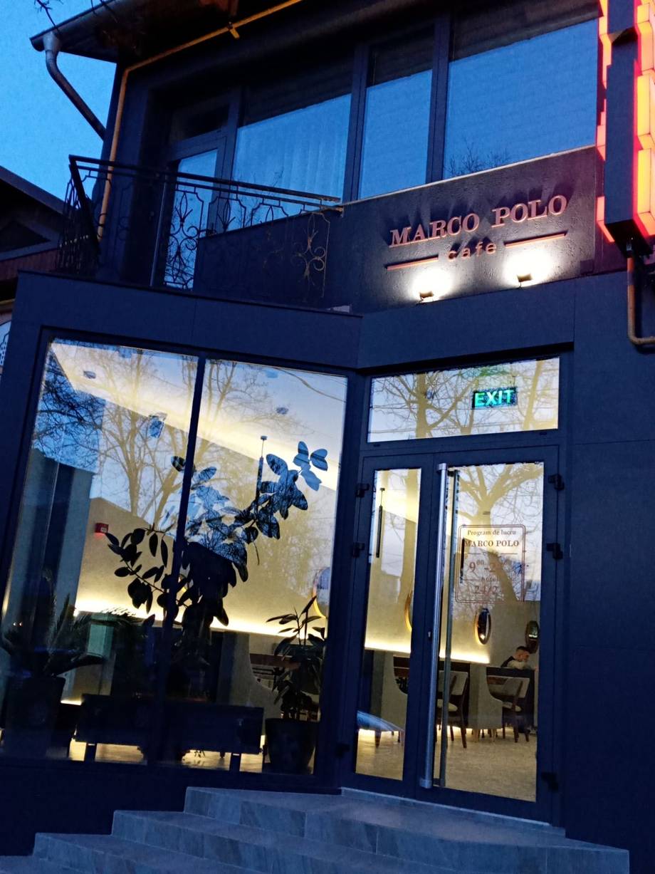 Marco Polo restaurant storefront at dusk with illuminated signage and glass entrance