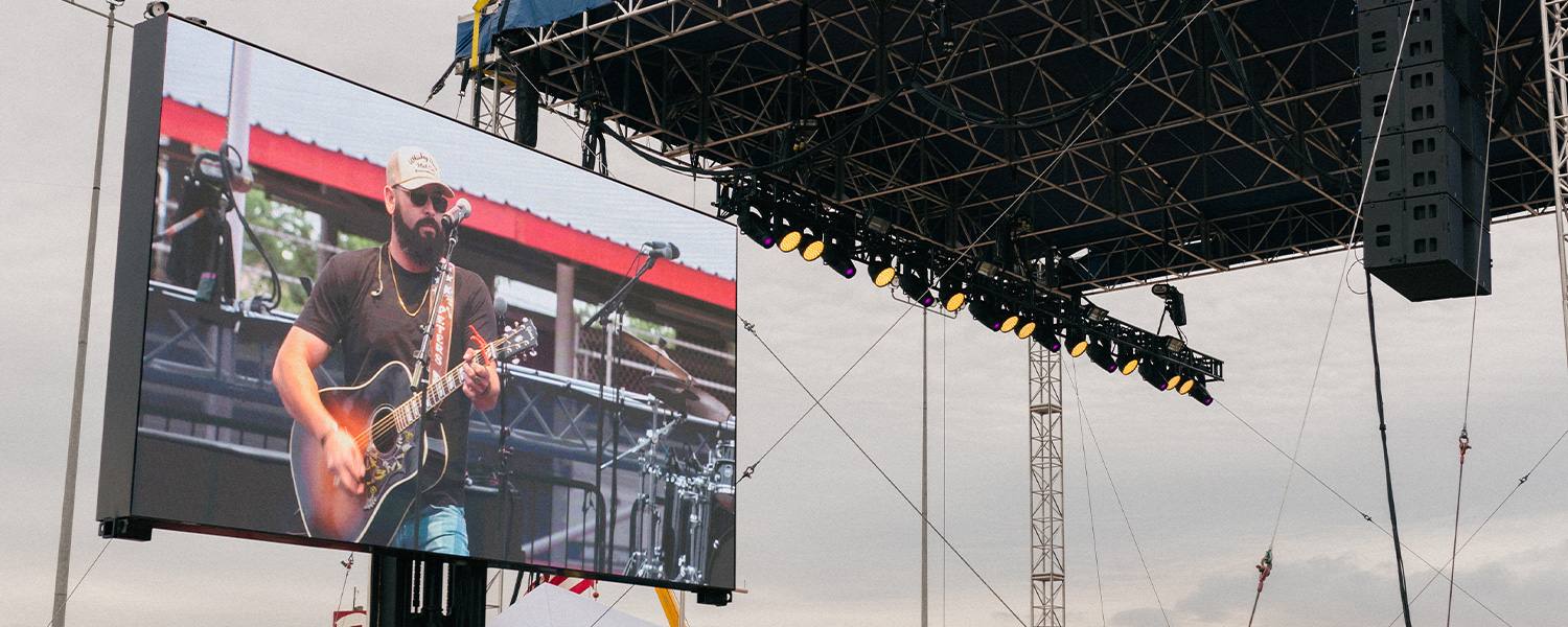 Live band performance on large outdoor venue screen during event