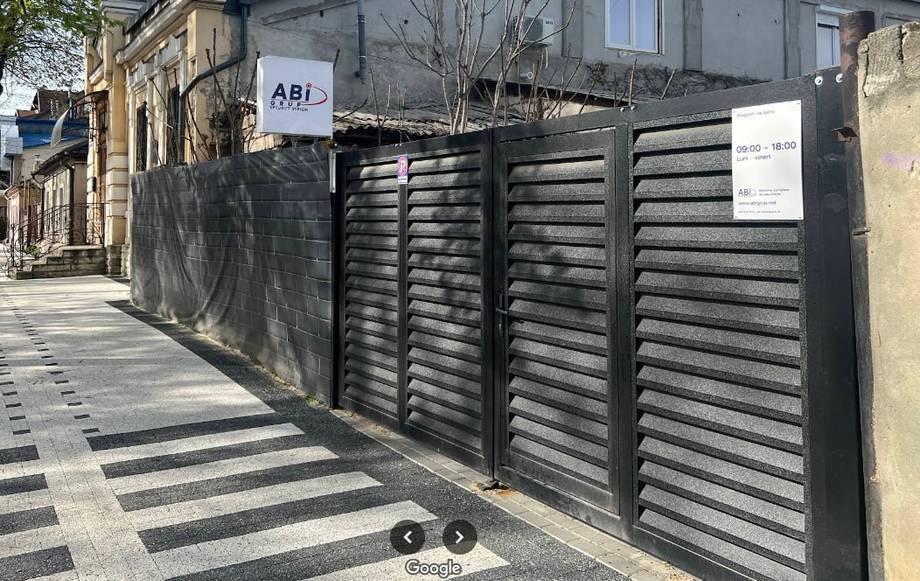 Modern black metal gate and facade entrance on cobblestone street