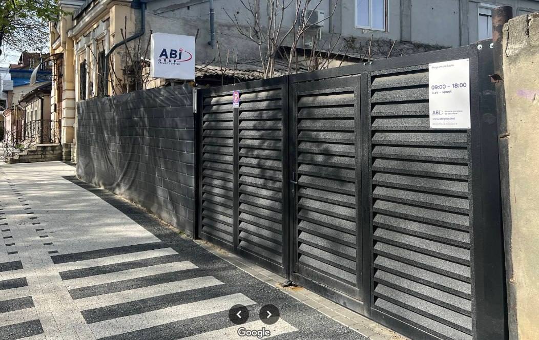 Modern black metal gate and facade entrance on cobblestone street