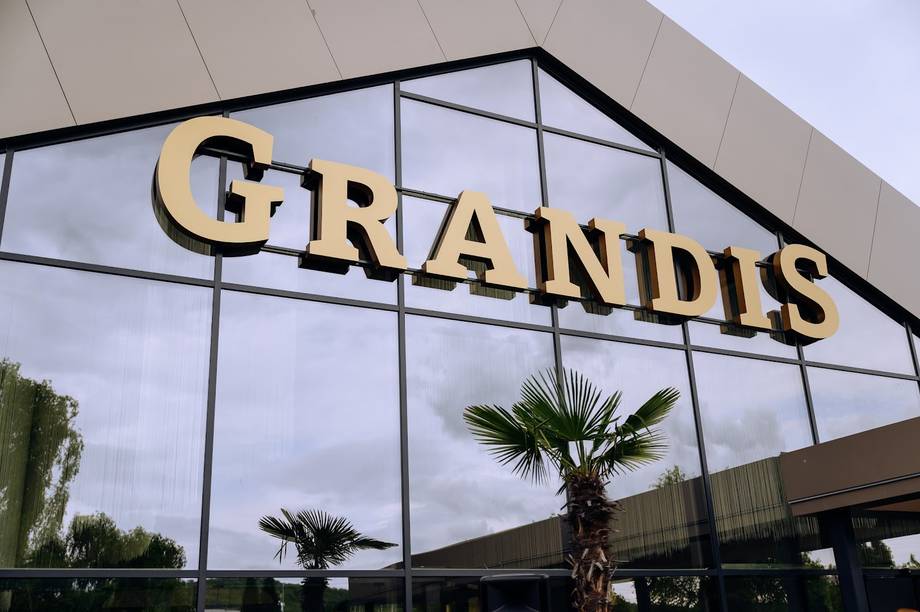Grandus storefront facade with illuminated signage and modern glass architecture