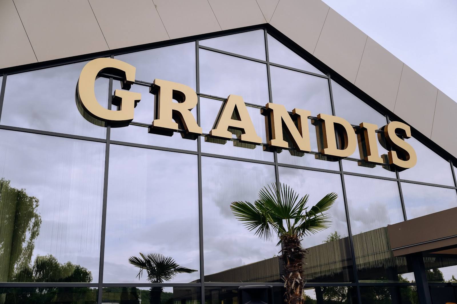 Grandus storefront facade with illuminated signage and modern glass architecture
