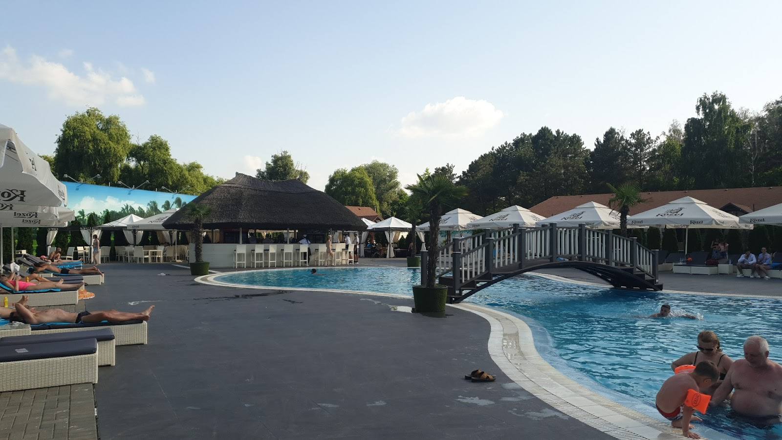 Outdoor pool complex with terrace, loungers, and recreational water areas