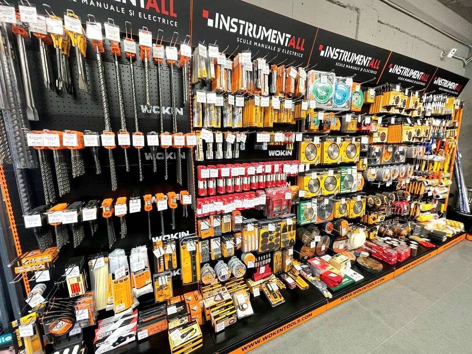 Hardware store display wall with tools, brushes, and construction supplies organized on shelves