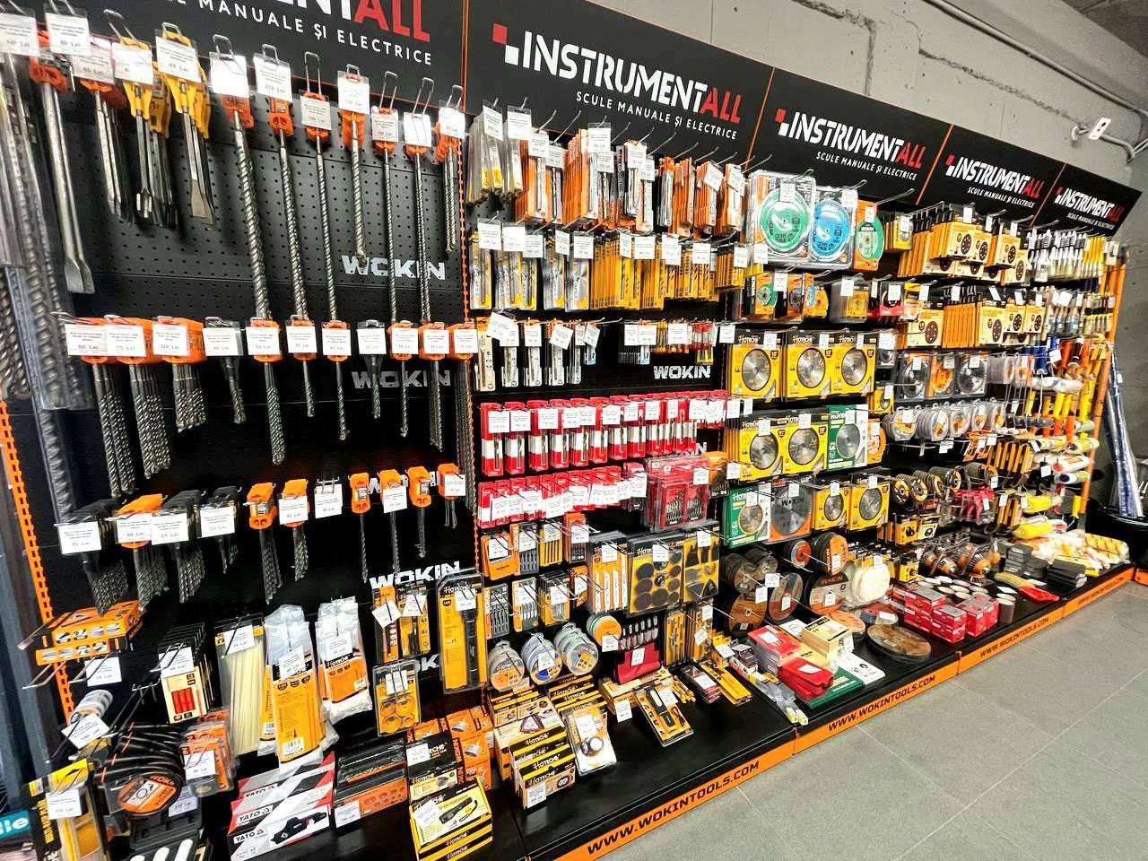 Hardware store display wall with tools, brushes, and construction supplies organized on shelves