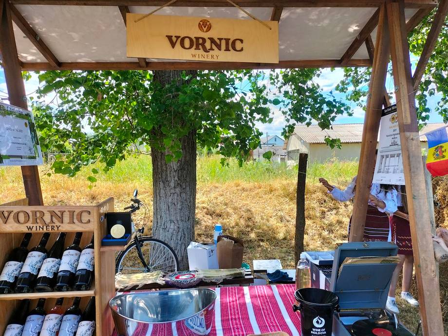 Vornic wine stand with products and rustic outdoor setup under wooden canopy