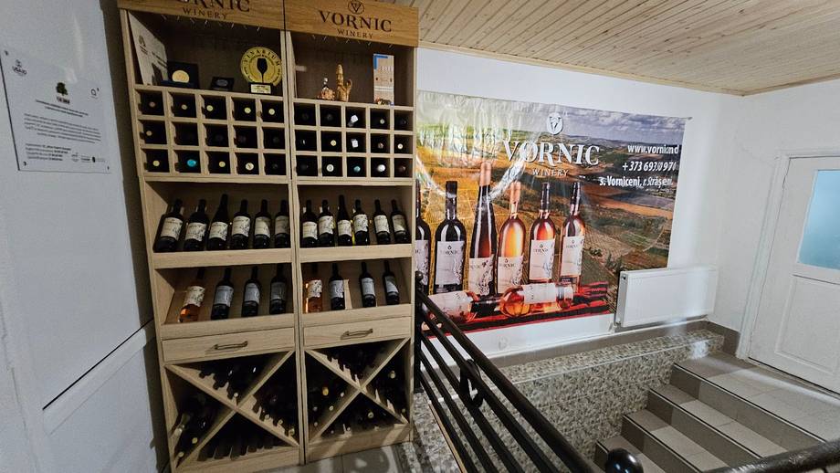 Wine shop interior with wooden display shelves and branded signage