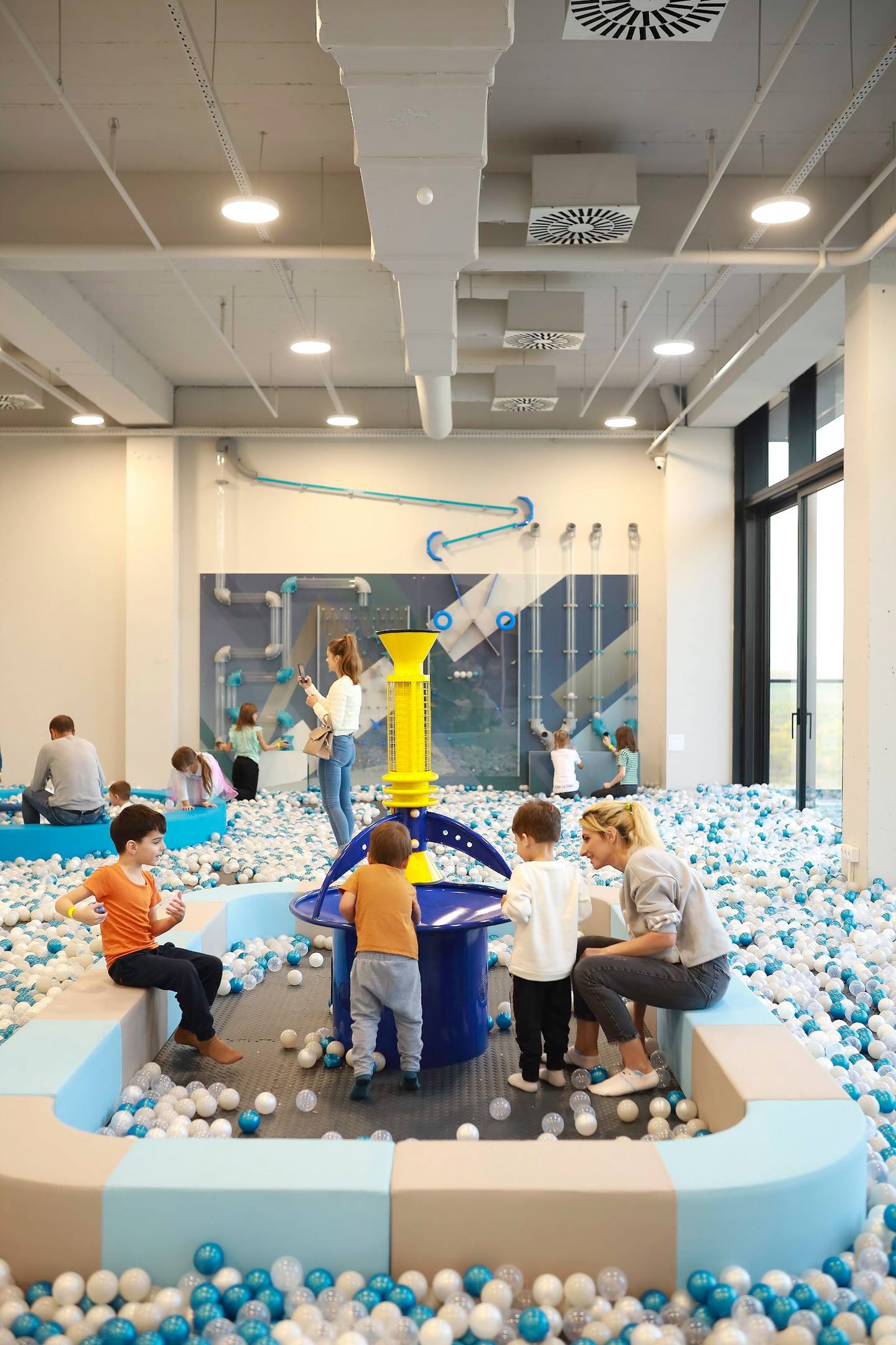 Interactive ball pit activity space with children playing in blue and white balls