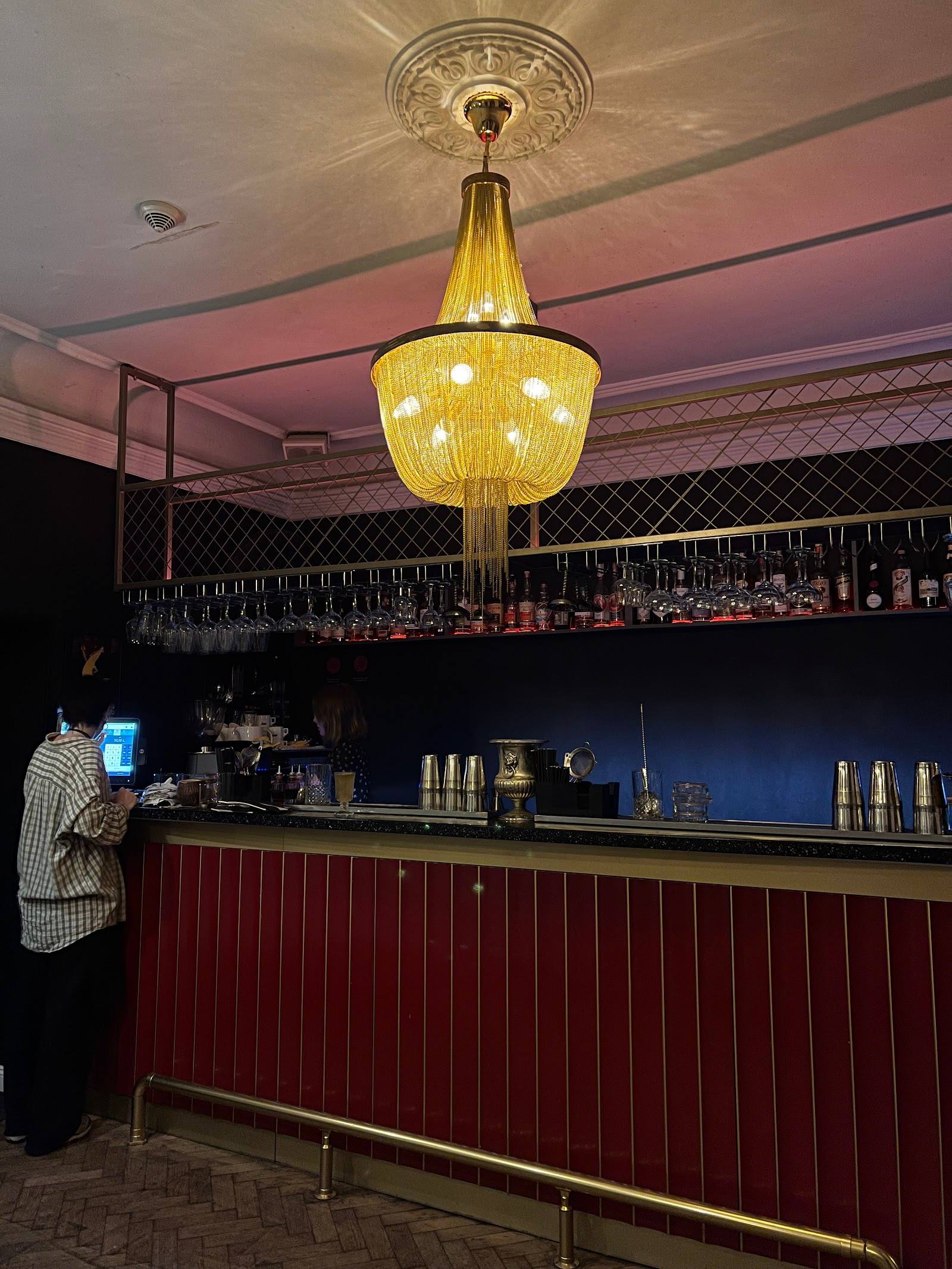 Elegant bar counter with amber pendant lighting and bottle display wall