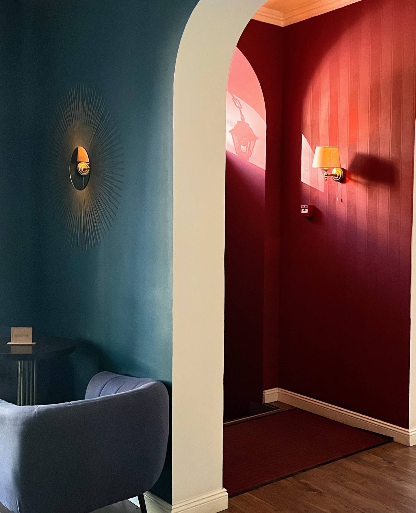 Modern lounge area with jewel-tone color blocking and ambient sconces