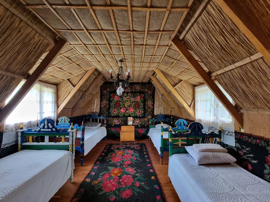 Traditional Moldovan wooden guesthouse interior with twin beds and exposed beam ceiling