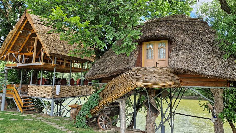 Distinctive thatched-roof structures with wooden platforms nestled among green trees