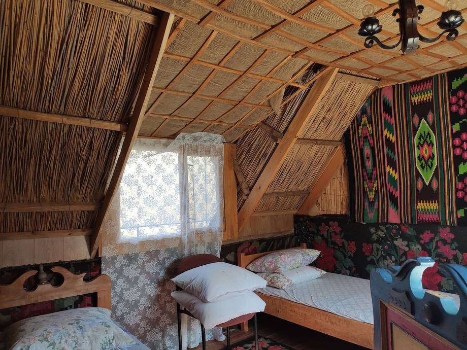 Rustic wooden bedroom interior with traditional textiles and sloped ceiling