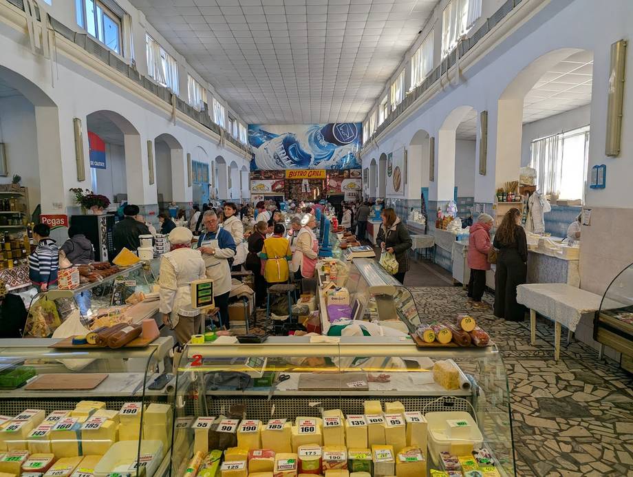 Farmers market interior with vendor stalls and shoppers in bright hall