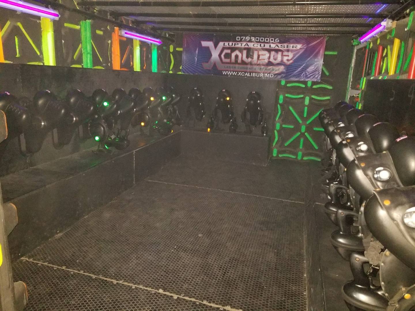 Indoor laser tag arena with neon signage and immersive lighting setup
