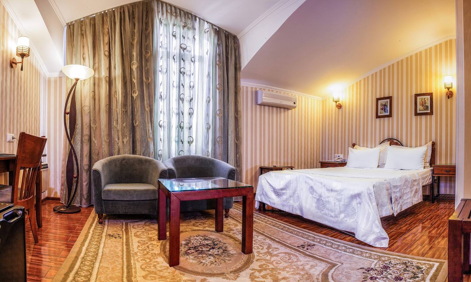 Elegant hotel bedroom suite with classic furnishings and ambient lighting