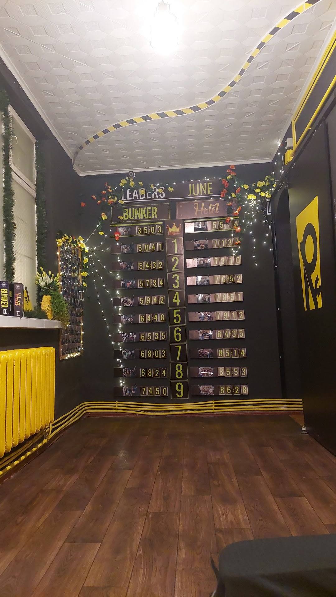 Escape room interior with leaderboard, yellow accents, and themed decorations