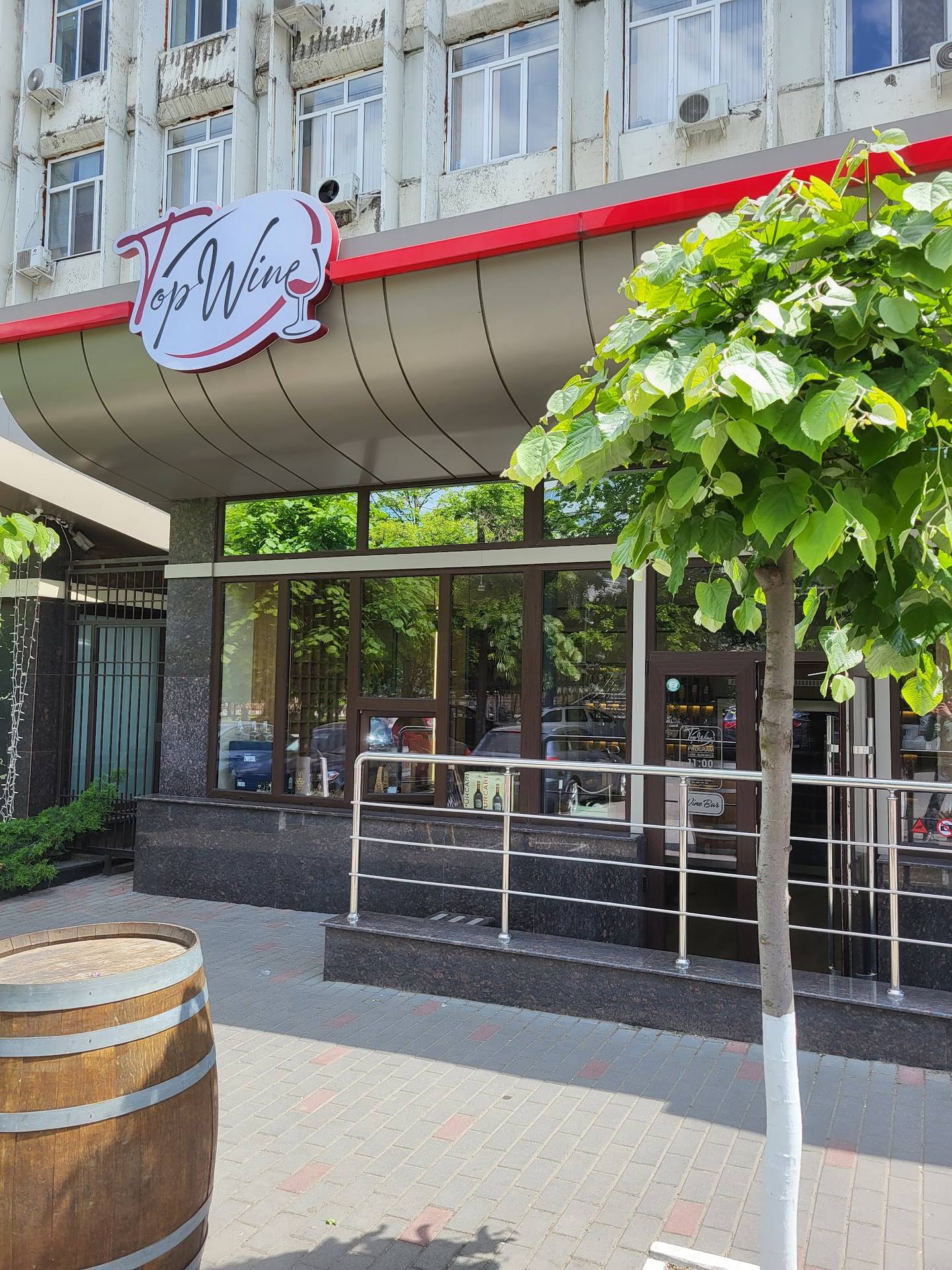 Wine bar storefront with red awning, large windows, and entrance signage