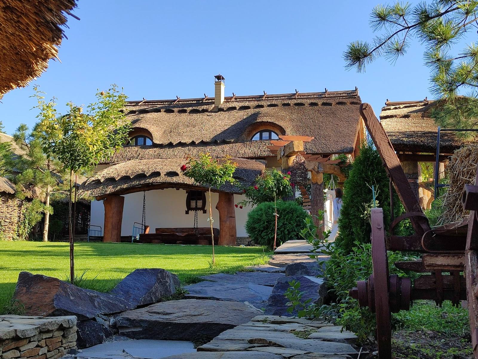 Rustic thatched-roof venue with manicured grounds and traditional architecture