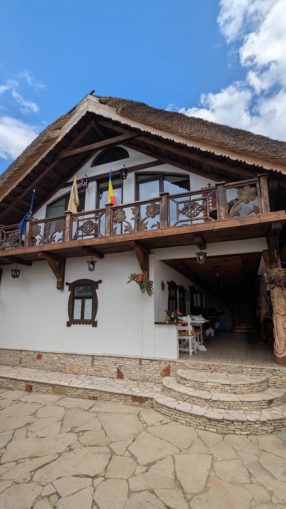 Traditional rural guesthouse with thatched roof and wooden balcony