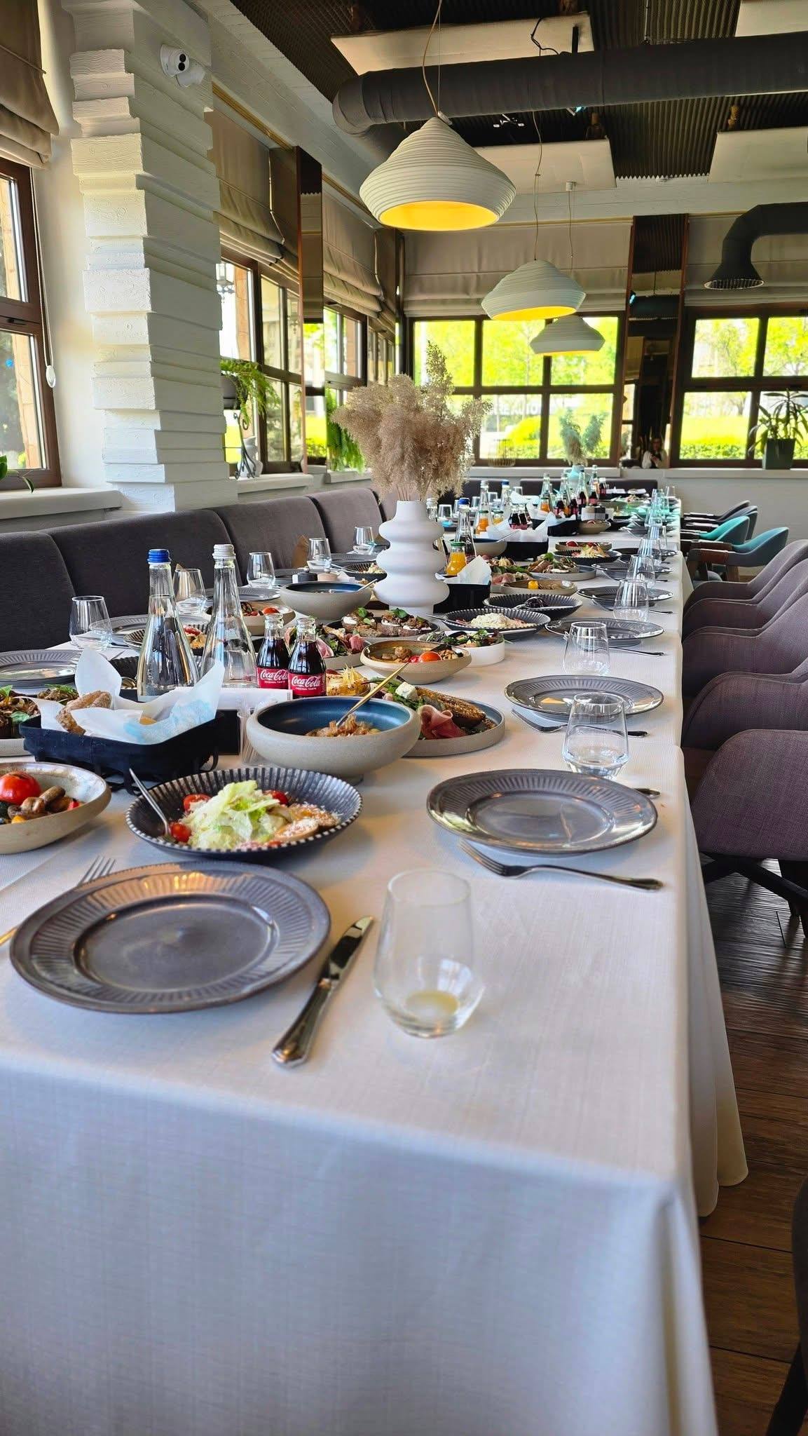 Elegant banquet table setup with natural light and modern interior space