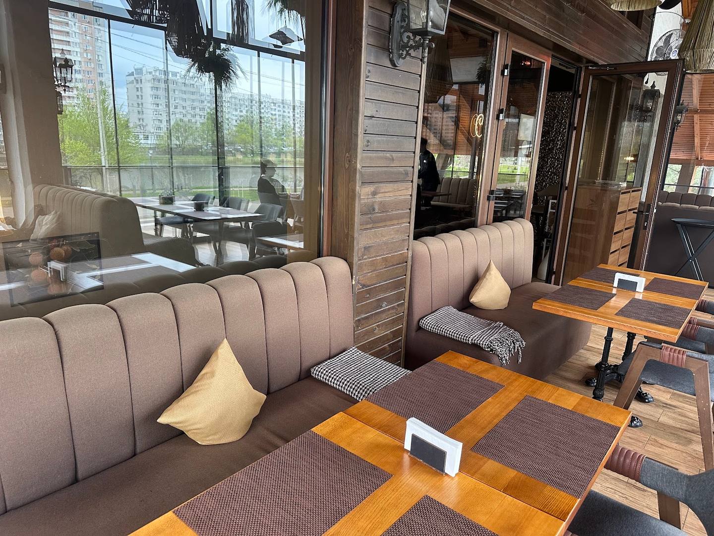 Modern café interior with banquette seating and large windows overlooking street