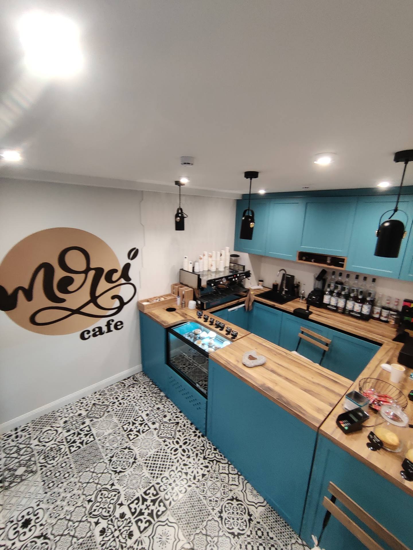 Mero cafe interior with turquoise counter and branded logo wall