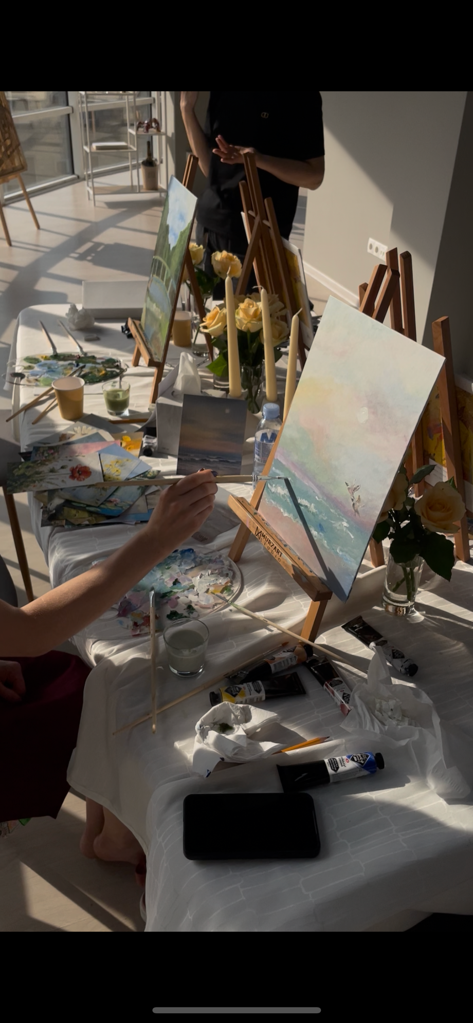 Art painting workshop with natural light and participant creating watercolor artwork