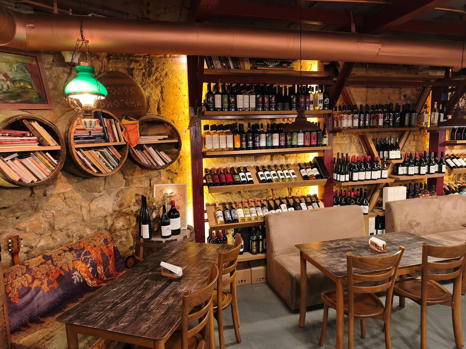 Wine bar interior with extensive bottle display, seating area, and industrial-chic decor