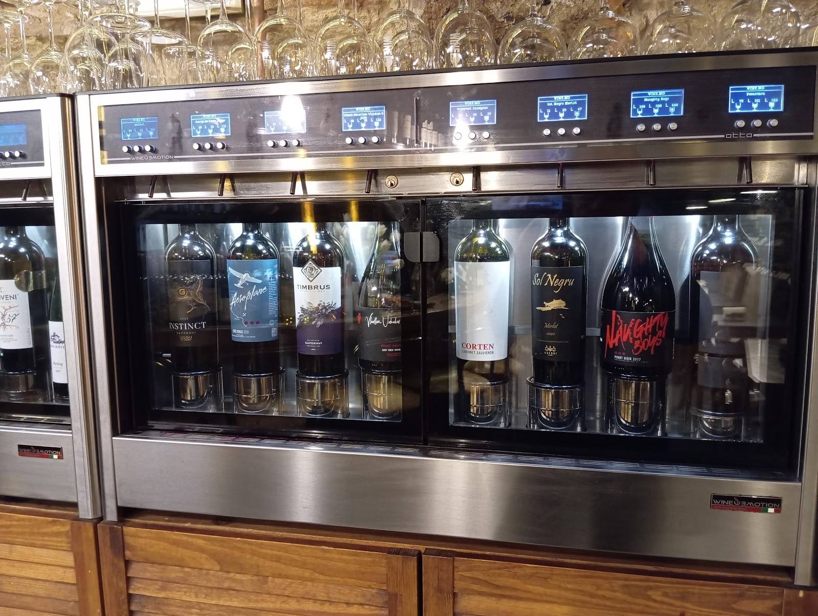 Wine bottles in temperature-controlled display cabinet with digital controls