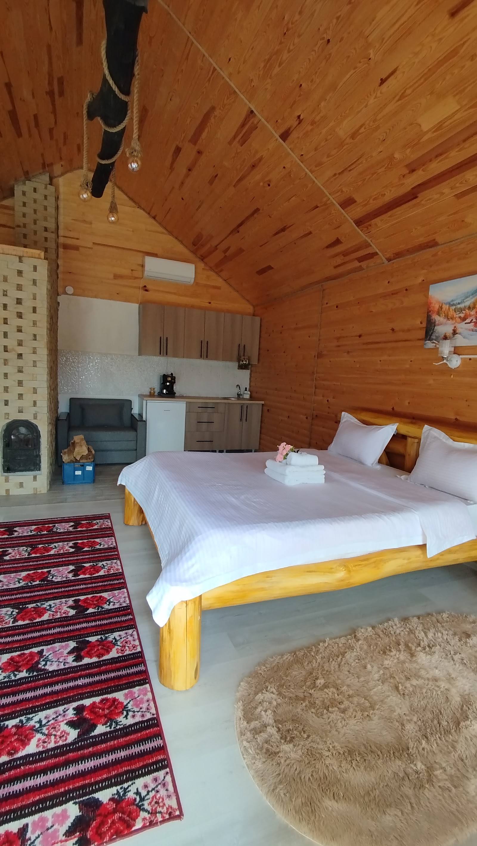 Cozy wooden cabin bedroom with en-suite kitchenette and ambient interior