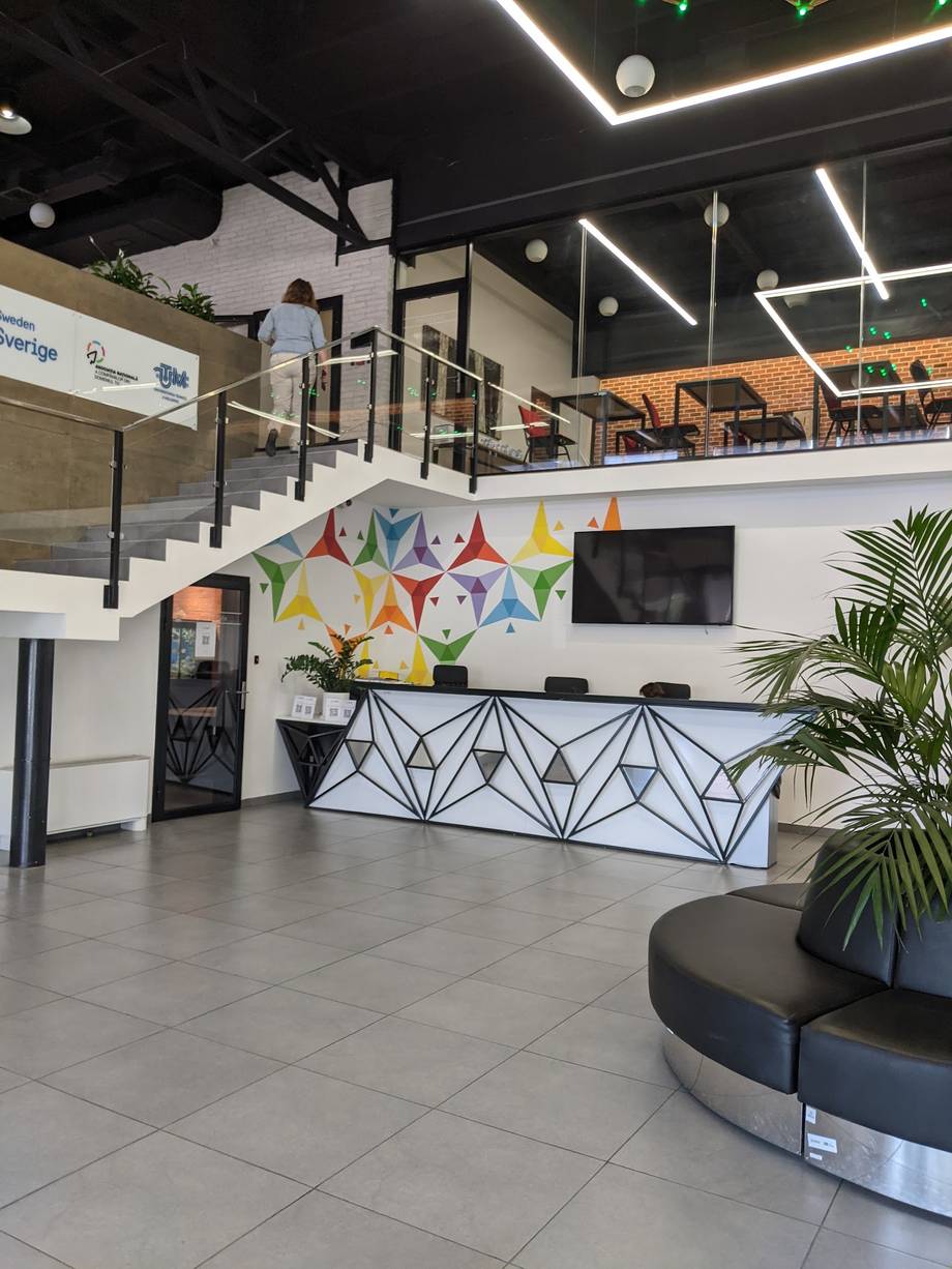 Modern activity venue interior with colorful reception area, mezzanine level, and contemporary design elements
