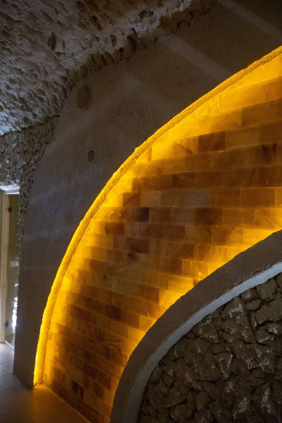 Stone cellar arch with warm ambient lighting highlighting the historic masonry and vaulted ceiling