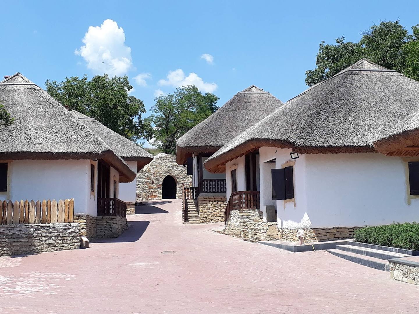Traditional thatched-roof buildings with white walls and terracotta courtyard layout