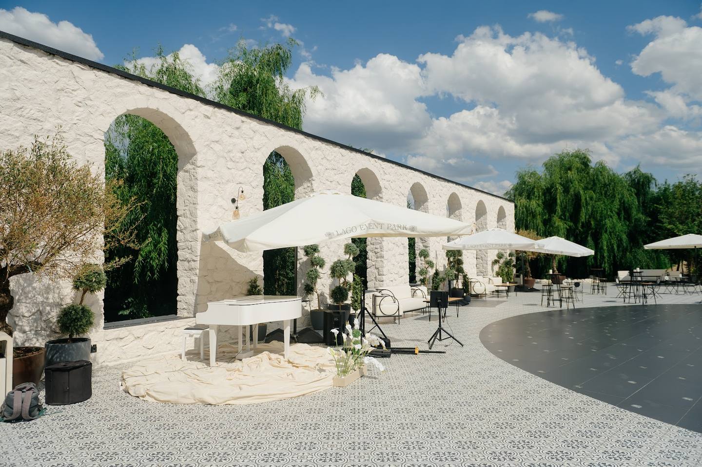 Contemporary event venue with white arched architecture, terrace, and waterfront setting